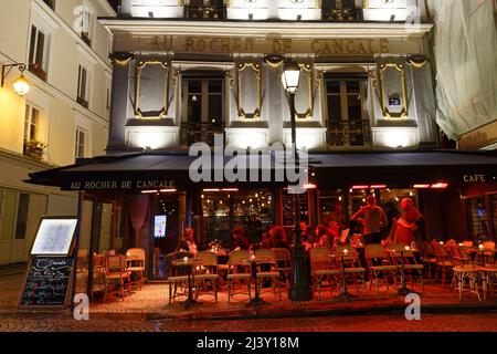 Persone seduti in un tradizionale caffè francese Au rocher de Cancale in Rue Montorgueil notte piovosa , Parigi, Francia. Foto Stock