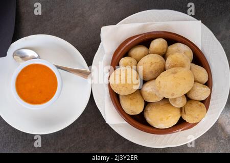 Papas arrugadas in piastra di argilla e salsa mojo piccante sul lato dall'alto. Tradizionale rughe patate snack cibo da Gran Canaria isola, Spagna Foto Stock
