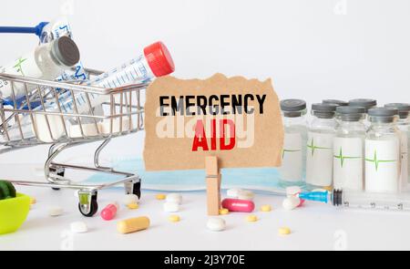 primo piano di un manuale di pronto soccorso di emergenza con occhiali neri appoggiati sulla parte superiore. Cosa fare in uno scenario di incidente d'emergenza. Foto Stock