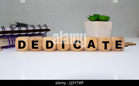 Parola dedicata su una fila di blocchi di legno. Devozione dedizione amore concetto Foto Stock