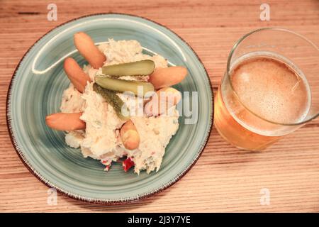 Tapa di insalate russe accanto alla birra fredda su un banco bar spagnolo Foto Stock