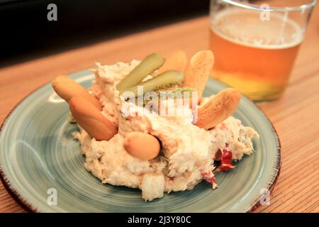 Tapa di insalate russe accanto alla birra fredda su un banco bar spagnolo Foto Stock