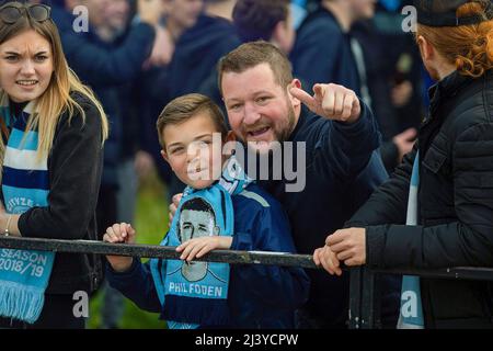 Manchester, Regno Unito. 10th Apr 2022. Un padre e suo figlio si preparano per l'arrivo del pullman cittadino. I fan di Manchester City hanno dato il benvenuto all'Etihad Stadium. I fan cantarono a voce alta, si gettarono il fumo e dimostrarono il loro sostegno alla squadra mentre l'allenatore guidava nello stadio. Il gioco contro Liverpool è stato considerato un gioco ad alto rischio e ridotto i biglietti per i fan sono stati venduti. Credit: SOPA Images Limited/Alamy Live News Foto Stock