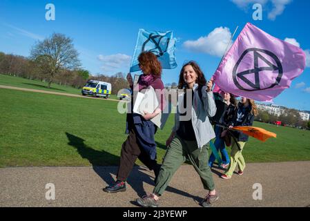 Le donne che arrivano per le proteste della ribellione di estinzione, lanciando un periodo di disgregazione civile a Londra dal 9 aprile 2022. Furgoni della polizia a Hyde Park Foto Stock
