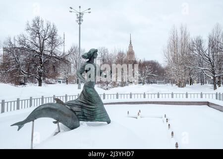 Mosca. Russia. Aprile 3, 2022. Statua scultorea di una ragazza e un delfino sullo sfondo di un parco nevoso. Foto Stock