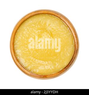 Salsa di mele in una ciotola di legno. Salsa di mele cotte e sbucciate, una salsa gialla. Foto Stock