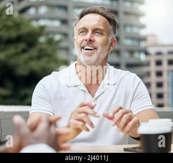 Recuperare casualmente con i suoi colleghi. Colpo di un uomo d'affari maturo che ha una pausa con i suoi colleghi fuori di un ufficio. Foto Stock