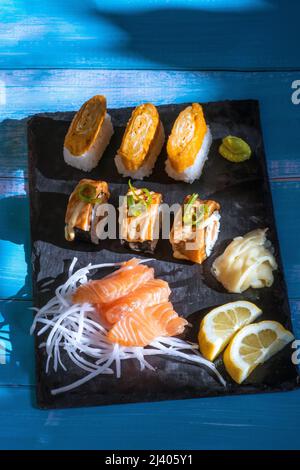 Sushi assortiti e piatto di sashimi. Involtini di sushi di salmone, sashimi di salmone, Wasabi, zenzero, limone. Foto Stock