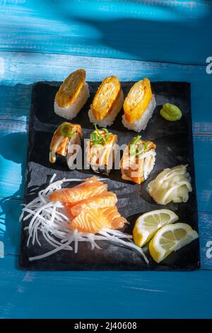 Sushi assortiti e piatto di sashimi. Involtini di sushi di salmone, sashimi di salmone, Wasabi, zenzero, limone. Foto Stock
