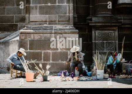 Gli artigiani vendono figure di palme durante la celebrazione della Domenica delle Palme fuori dalla Cattedrale di Puebla Foto Stock