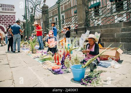 Gli artigiani vendono figure di palme durante la celebrazione della Domenica delle Palme fuori dalla Cattedrale di Puebla Foto Stock