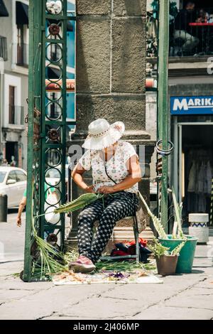 Gli artigiani vendono figure di palme durante la celebrazione della Domenica delle Palme fuori dalla Cattedrale di Puebla Foto Stock