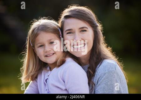 Non riesco ad immaginare la mia vita senza di lei. Ritratto corto di una giovane donna attraente e sua figlia che si posa fuori nel giardino a casa. Foto Stock