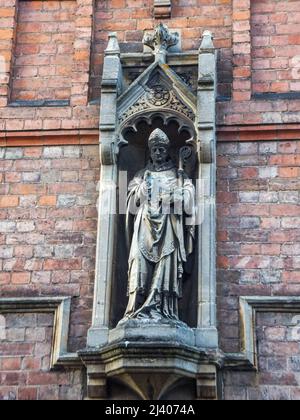 Una vecchia statua si erge in un'alcova sul muro di un edificio a Warwick, Warwickshire, Inghilterra, Regno Unito. Foto Stock