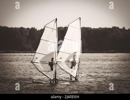 coppia windsurf sul lago senza vento Foto Stock
