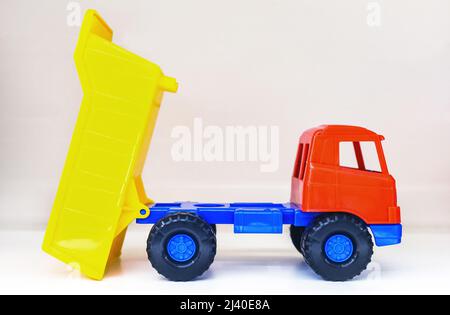 dumper ribaltabile colorato in plastica, su bianco (alterato a livello globale) Foto Stock