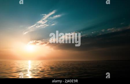 tramonto cielo nuvoloso sul mare aperto Foto Stock