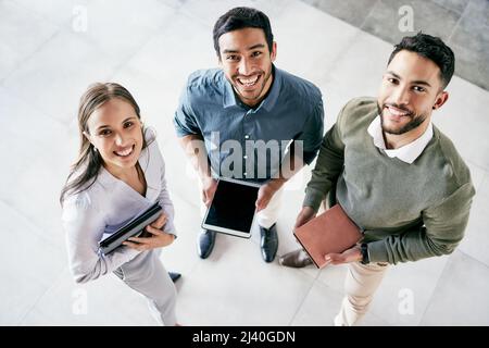 Possiamo ottenere qualsiasi risultato in team. Girato di un gruppo diversificato di uomini d'affari che si trovano in ufficio durante il giorno. Foto Stock