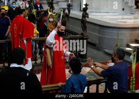 Non esclusiva: CITTÀ DEL MESSICO, MESSICO - Apr 10, 2022: Un vescovo benedica la palma dei fedeli durante la messa della Domenica delle Palme alla Cattedrale Metropolitana Foto Stock