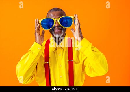 Cool uomo anziano con abito alla moda ritratto in stile su sfondo colorato - divertente vecchio pensionato maschio con stile eccentrico divertirsi Foto Stock