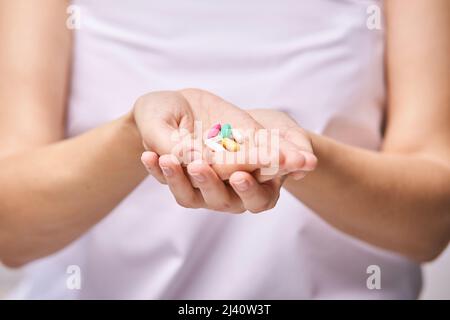 Donna mangiare pillole di gravidanza. Integratori influenzali. Assunzione di farmaci allergici. Pesce medico omega 3 cibo. Corpo della gente. Bere acqua. Mano madre. Donna malata a casa. Compressa giornaliera Foto Stock