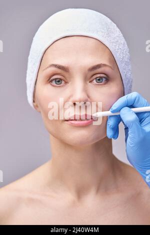 Cura della pelle estetista. Faccia matita make up. Trattamento viso. Dermatologia femminile. Procedura automatica. Applicazione del mascara con il dispositivo. Procedura Home. Lips Countour tinta. Concetto di bellezza Foto Stock