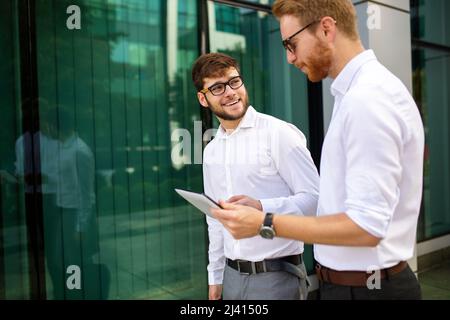 Due uomini d'affari di successo che camminano all'aperto. Business, amicizia, comunicazione concetto Foto Stock