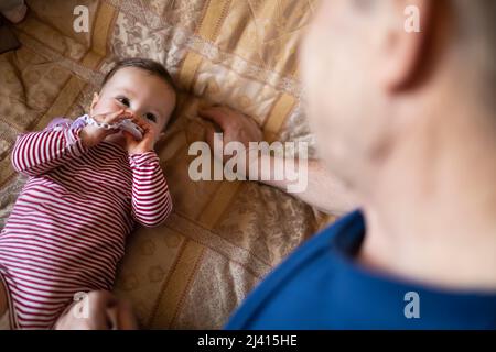 Piccolo bambino che gioca con il suo nonno Foto Stock