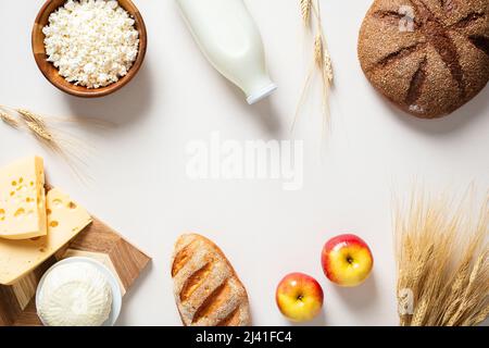 Prodotti lattiero-caseari, pane, frumento, formaggio casereccio, mele, formaggio su sfondo bianco. Simboli di vacanza ebraica - Shavuot Foto Stock