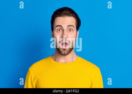 Ritratto di attraente divertente stupito ragazzo brunet improvvisa reazione notizie isolato su sfondo blu brillante Foto Stock