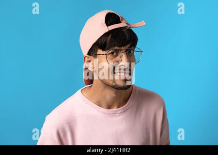 Curioso ragazzo medio-orientale che tiene la mano per l'orecchio Foto Stock