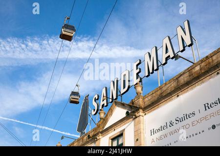 L'insegna sul tetto della storica cantina 'Sandeman' Port, sotto la funivia, Vila Nova de Gaia, Porto, Portogallo, Europa Foto Stock