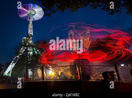 Alla luce tracce da 'evoluzione' in primo piano e "Air" in background a St Giles fiera, Oxford. Settembre 2012 Foto Stock