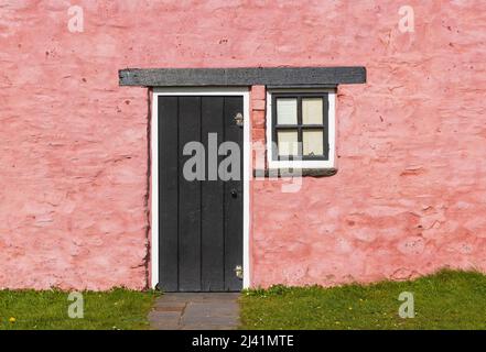 Vecchia porta e finestra in legno su un vecchio muro in pietra dipinta. Foto Stock