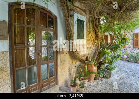 La porta e il giardino di una casa tradizionale nel villaggio di Fornalutx. Maiorca, Isole Baleari, Spagna. Foto Stock