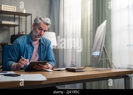 Architetto uomo maturo che lavora al computer alla scrivania in ufficio. Foto Stock