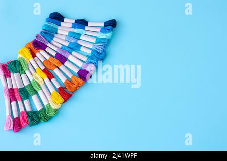 Filettature di colori diversi su sfondo blu. Foto Stock