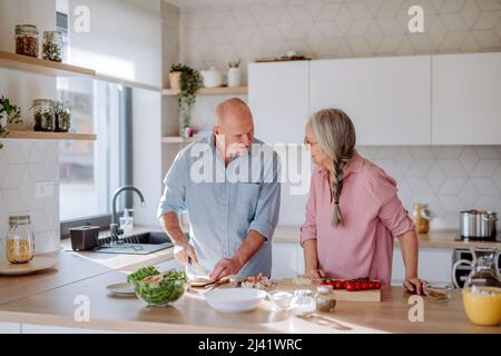 Felice coppia senior che cucinano insieme a casa. Foto Stock