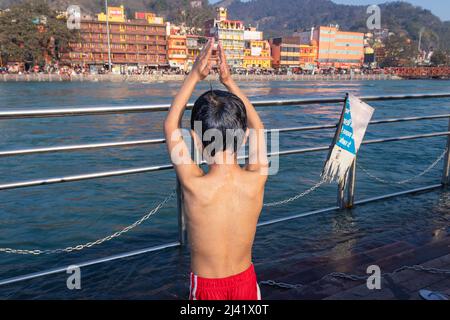 giovane capretto che fa pryer religioso di fiume al mattino da immagine piatta angolo è preso a haridwar uttrakhand india. Foto Stock