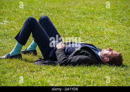 LONDRA, REGNO UNITO. 11 aprile 2022 . Un uomo che bagna il sole in Green Park come temperature più alte sono previste per il week-end di Pasqua banca di vacanze a Londra e sud dell'Inghilterra credito: amer Ghazzal / Alamy Live News Foto Stock