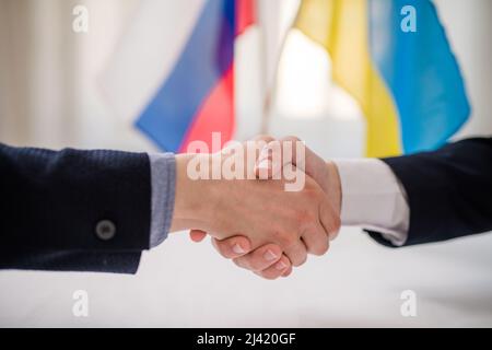 I rappresentanti dell'Ucraina e della Russia scuotono le mani, concetto di accordo di pace dell'Ucraina. Foto Stock