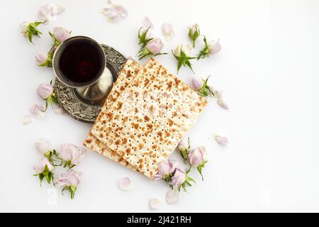 Festa di Pesah, Pasqua ebraica. Matzah e kosher rosso. Tradizionale pane ebraico rituale su sfondo bianco Foto Stock