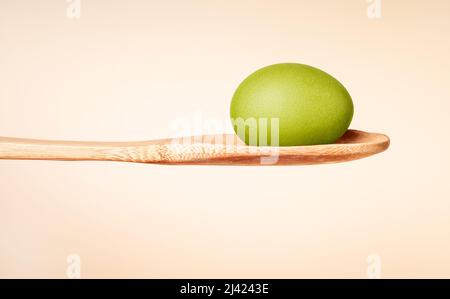 Uovo di Pasqua tinto verde in cucchiaio di legno. Tradizione religiosa festa celebrazione. Cottura e pittura processo. Foto di alta qualità Foto Stock