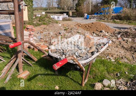 Carriola contenente le macerie di un edificio. Foto Stock