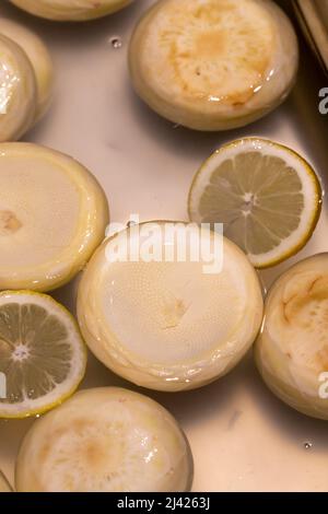 Carciofi crudi. Carciofi sbucciati freschi sul bancone del mercato. Primo piano Foto Stock