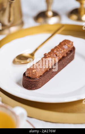 Torta al cioccolato con briciole di nocciole decorata su sfondo chiaro. Foto Stock