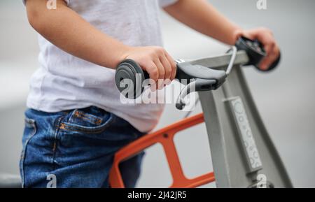 Vista ravvicinata del manubrio della bicicletta mentre si guida la bicicletta Balance all'aperto. Foto Stock