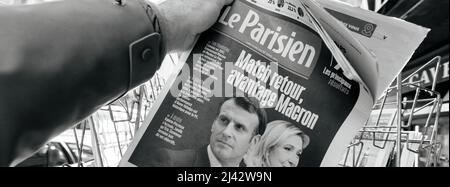 Parigi, Francia - Apr 11: L'uomo acquista guarda il chiosco della stampa alla copertina del quotidiano francese le Paries Emmanuel Macron, Marine le Pen un giorno dopo il primo turno delle elezioni presidenziali francesi il 10 2022 aprile Foto Stock