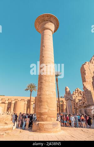 11 gennaio 2022, Luxor, Egitto: Folle di turisti camminano attraverso l'antico tempio di Karnak tra le antiche colonne enormi Foto Stock