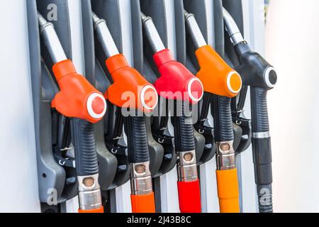 Pistole a benzina colorate pompano ugelli di riempimento, rifornimento stazioni di gas in un servizio Foto Stock